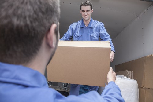 Removal van team loading household belongings into a moving vehicle