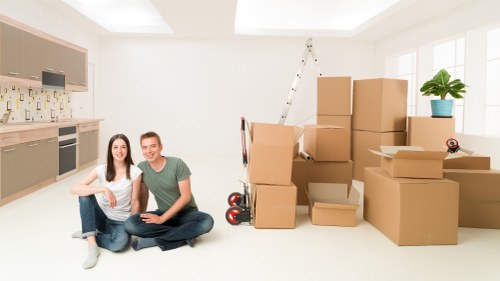 Movers carrying household items through a narrow staircase in an Islington property